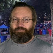 Glasses-wearing man with brown hair, mustache and full beard